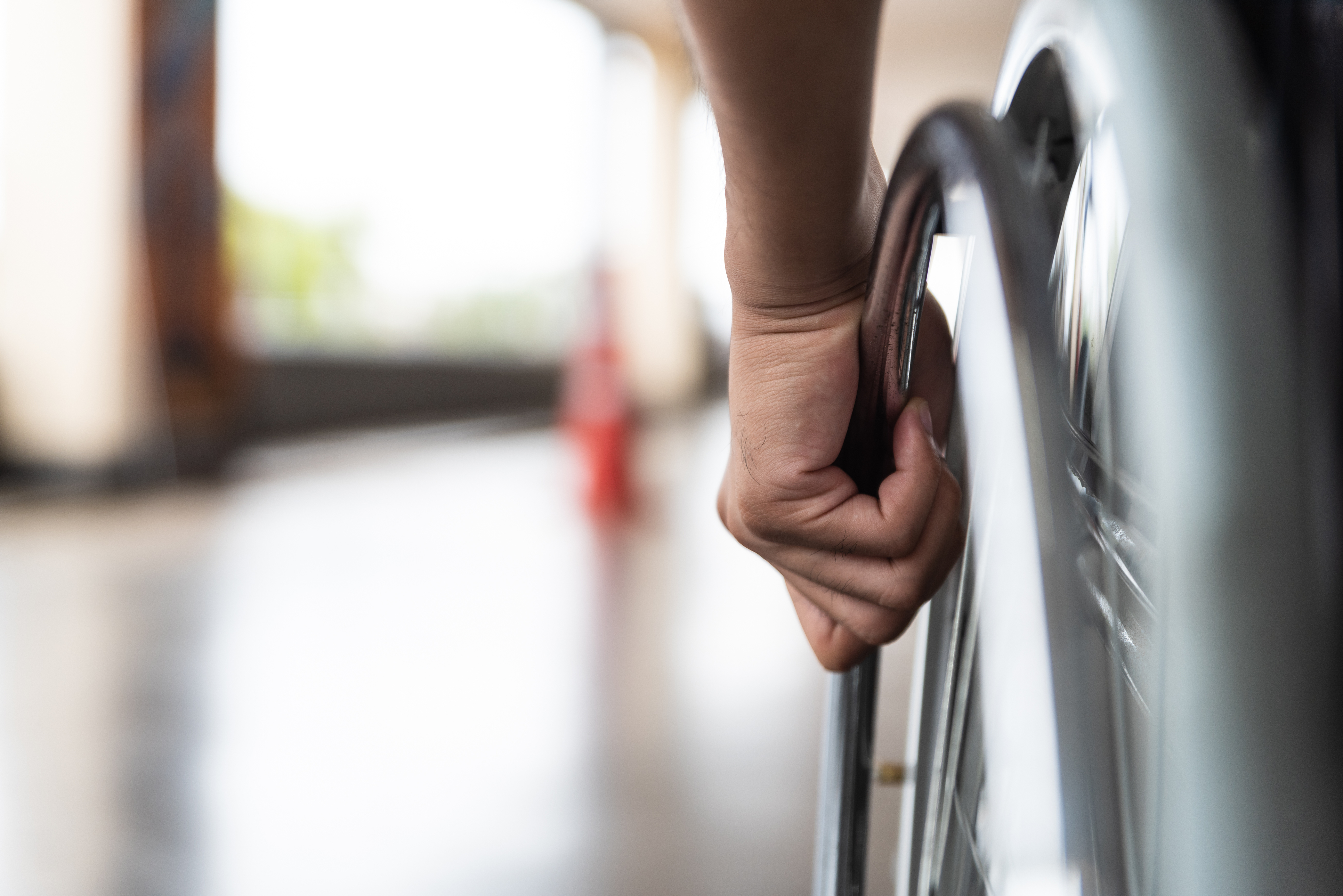 close-up image of a hand on a wheelchair wheel