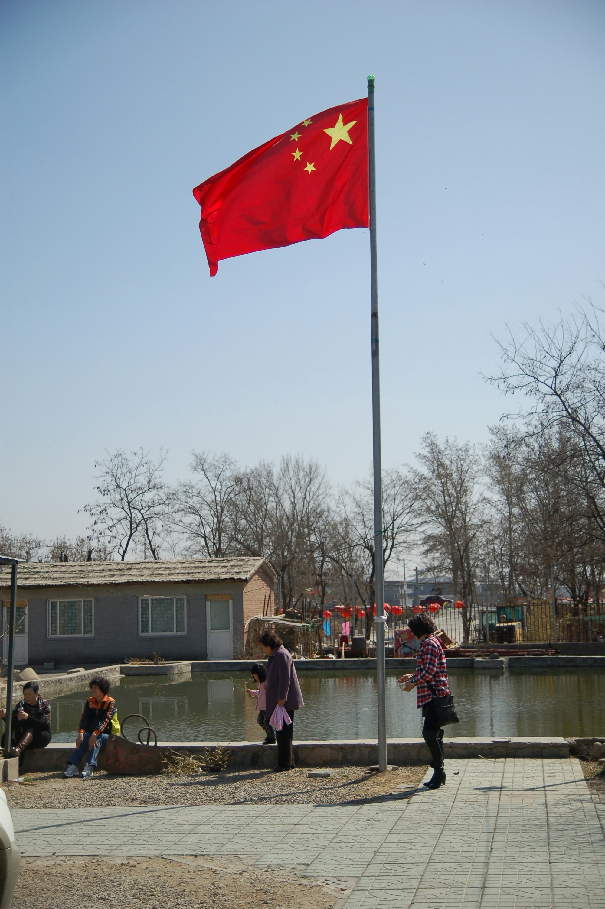 a photo of a flagpole with the Chinese flag flying