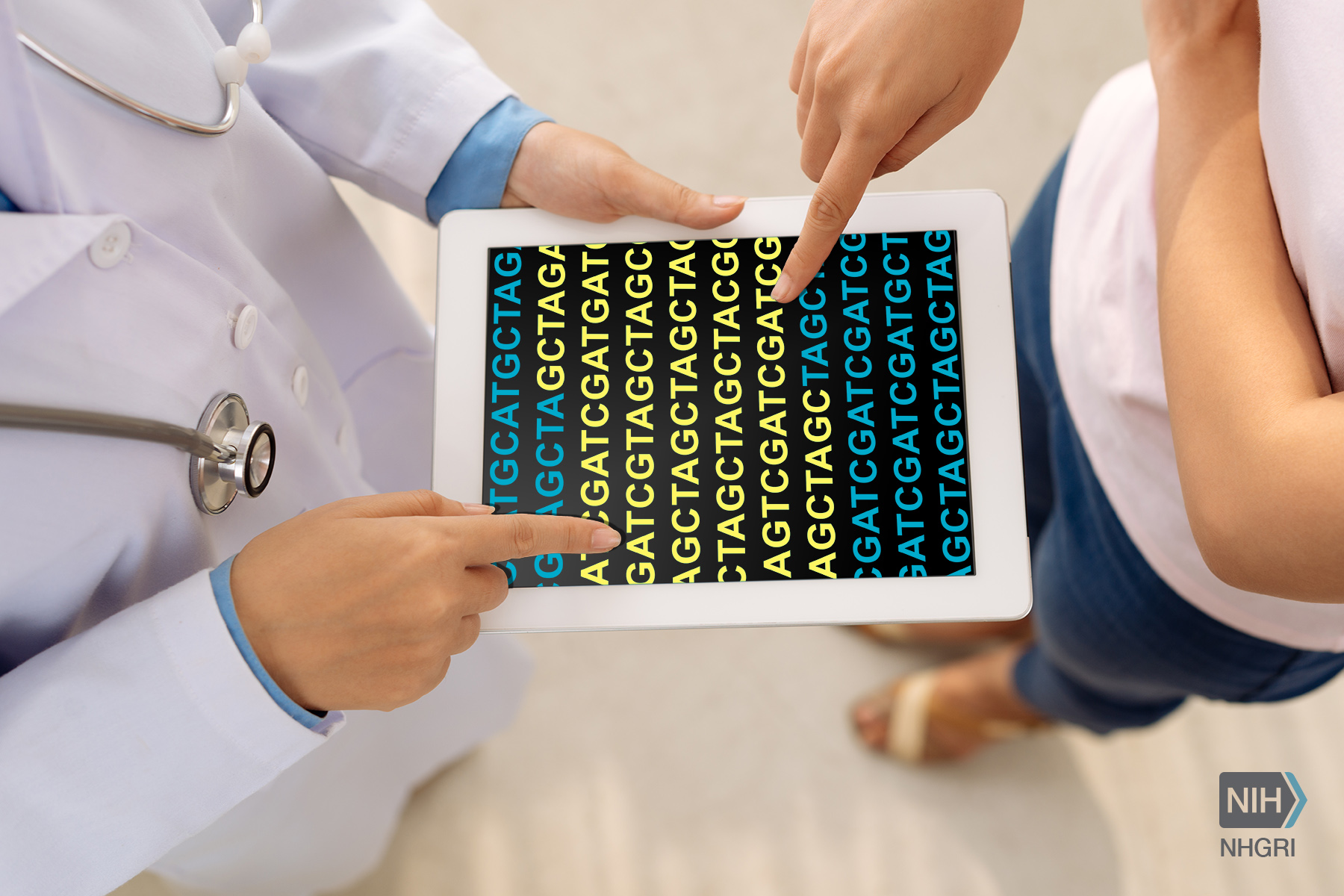 Bird's eye view of a doctor holding an iPad that contains a DNA sequence. Another person stands pointing specifically to the sequence.