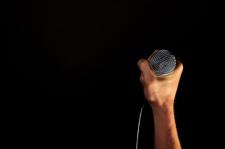 A human hand grips onto a microphone.
