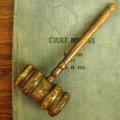 A court gavel lays on top of a court ruling book.