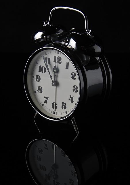 Black and white image of an alarm clock. Its time reads 11:55:30 seconds