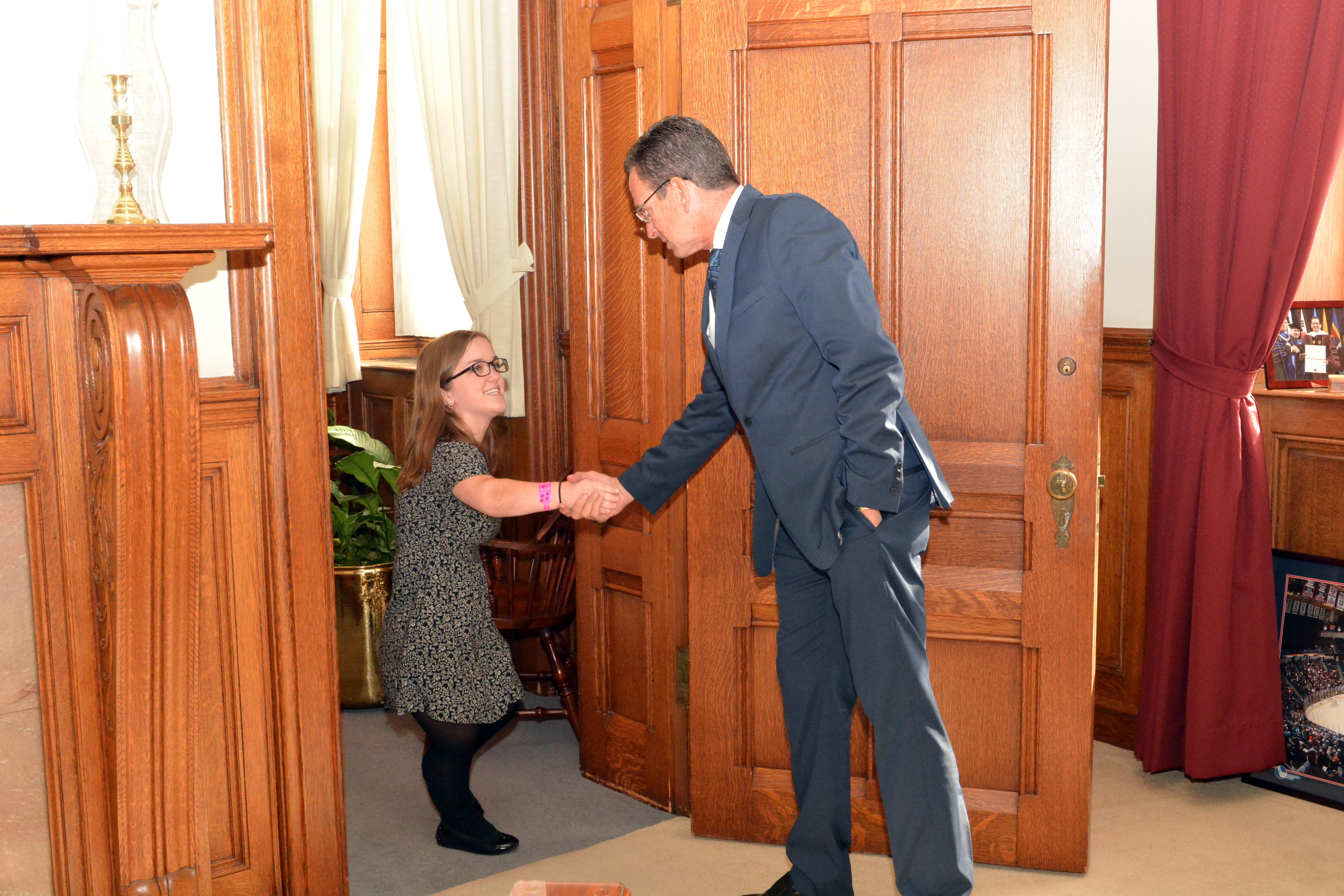 a little person shakes hands with a politician