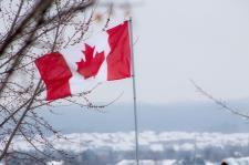 Canadian flag flies against the winter air.