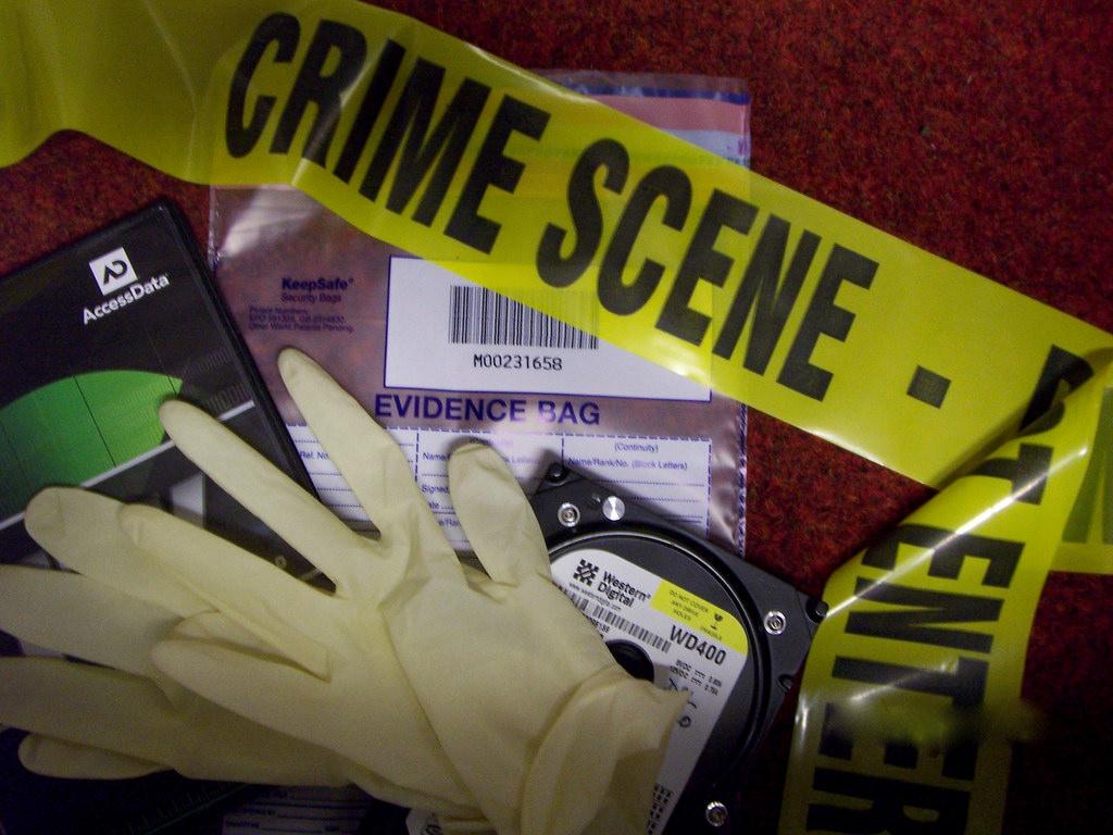 Forensic materials on a red background--gloves, crime scene tape, and evidence bags