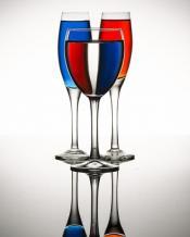 Three wine glasses are pictured. One glass has a red liquid, another has a blue liquid. The final glass picture has a clear transparency, which displays the red and blue glasses through it.