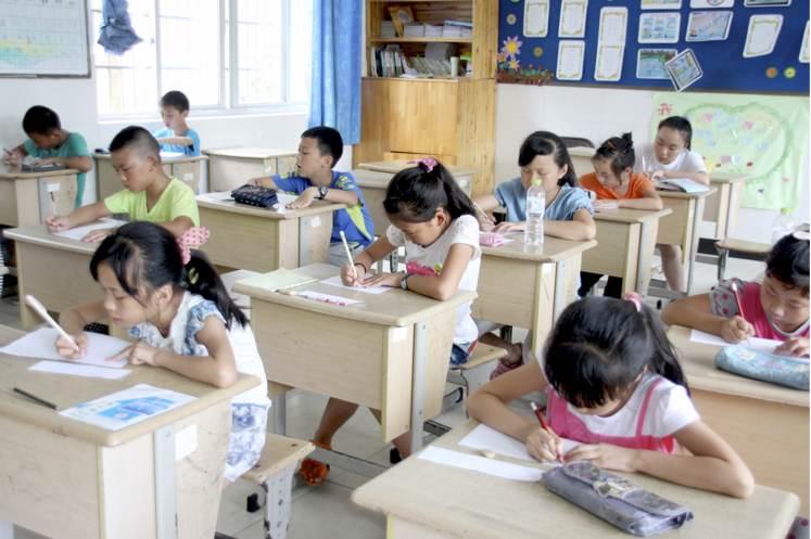 A group of Japanese 10 year olds sitting at there school desks.