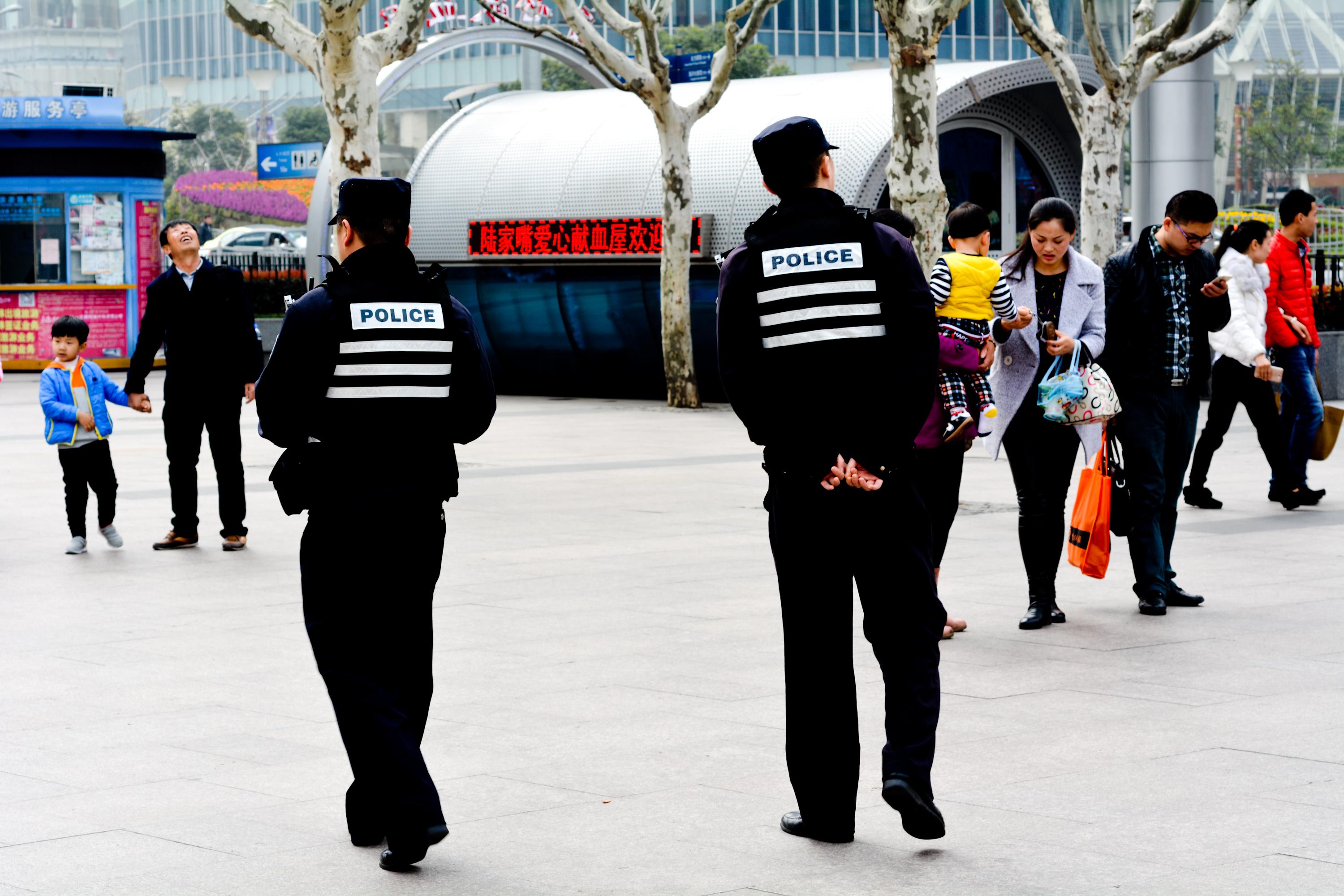 Two police officers in China patrol a city square